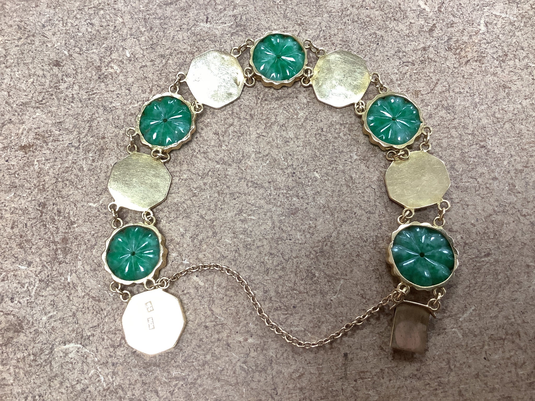 A Chinese yellow metal (stamped WH 20) and carved jadeite disc set bracelet, 18cm, gross 19 grams.